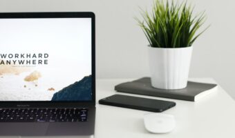 MacBook Pro near green potted plant on table